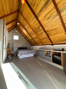 a large room with a bed and wooden ceilings at Chalés Pôr do Sol in Mucugê