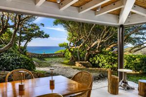 a dining room with a table and a view of the ocean at Porto Cervo Sea and Nature Villa in Porto Cervo