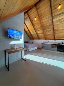 a bedroom with a bed and a tv on a wall at Chalés Pôr do Sol in Mucugê