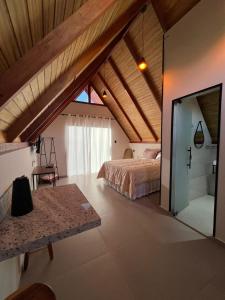 a bedroom with a bed and a glass door at Chalés Pôr do Sol in Mucugê