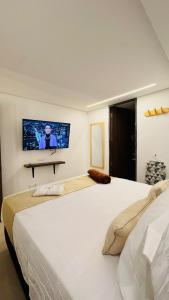 a bedroom with a large bed with a tv on the wall at Hotel Jelt Aeropuerto in Bogotá