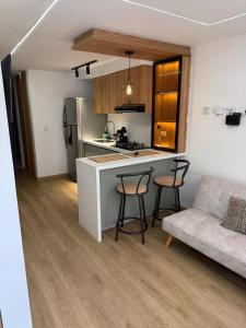 a kitchen and living room with a counter and chairs at Boreal House in Manizales