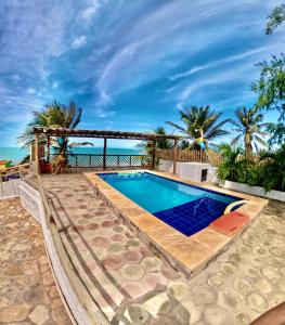 a swimming pool with a view of the ocean at Casa Mar Alto in Icapuí