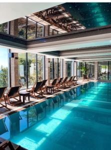 a swimming pool with chairs in a building at Kopaonik Mountain Retreat in Cajetina