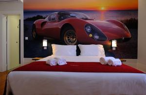 a bedroom with a bed with a car on the wall at Republica Vintage House in Viana do Castelo