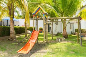 a playground with an orange slide and palm trees at Cabañas La Fragata Coveñas in Coveñas