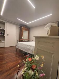 a room with a bed and flowers in it at Casa Di Orfea in Perosa Argentina