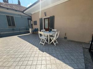 a patio with a table and chairs in a house at Casa Di Orfea in Perosa Argentina