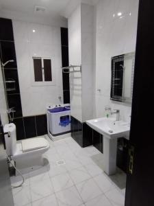 a white bathroom with a toilet and a sink at تميز المروة - حي المروة in Jeddah