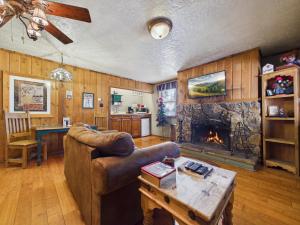 a living room with a couch and a fireplace at Whispering Pine Cabins in Ruidoso