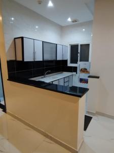 a kitchen with a counter with a sink and a refrigerator at تميز المروة - حي المروة in Jeddah