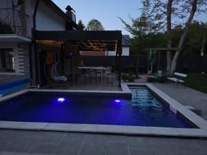 a swimming pool with blue lights in a backyard at Villa Kristal Slatina- Private Pool & Jacuzzi BBQ in Slatina Varoš