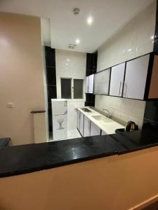 a kitchen with white cabinets and a black counter top at تميز المروة - حي المروة in Jeddah +26 photos