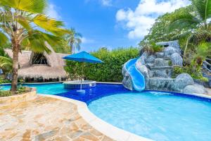 a pool with a water slide in a resort at Cabañas Aqua Blue Coveñas in Coveñas
