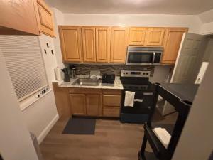 a small kitchen with wooden cabinets and a stove top oven at Peace & Relax sensation in Washington, D.C.