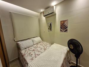 a small bedroom with a bed and a fan at Apartamento Confortável in Ananindeua +17 photos