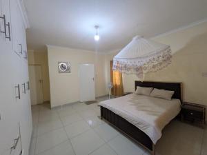 a bedroom with a bed with a chandelier above it at Rehoboth Area 49 Guest House in Lilongwe