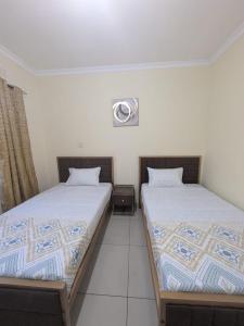 two beds sitting next to each other in a room at Rehoboth Area 49 Guest House in Lilongwe +6 photos