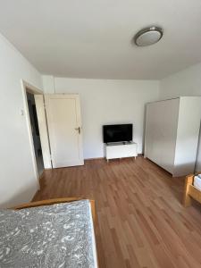 an empty living room with a television and a white cabinet at Guestroom Hannover Messe in Hannover