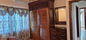 a bathroom with a wooden cabinet and a mirror at Gumbsie Villas in The Valley