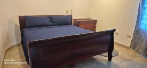 a bed with a wooden frame and a dresser in a bedroom at Gumbsie Villas in The Valley
