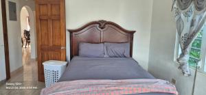 a bed with a wooden headboard in a bedroom at Gumbsie Villas in The Valley