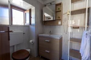 a small bathroom with a toilet and a sink at Case Vacanze Albamarina in Lipari +128 photos