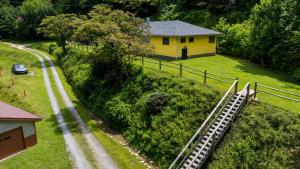 a small yellow house with a train on a hill at Slay The Dragon Dragon's Lair Cabin in Robbinsville, North Carolina w Creek in Robbinsville +50 photos