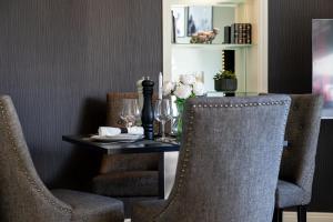 a dining room table with two chairs and a table with flowers at Stirling Riverview Apartment - Free Parking in Stirling