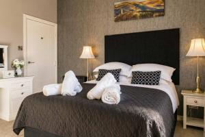 a bedroom with a large bed with towels on it at Stirling Riverview Apartment - Free Parking in Stirling