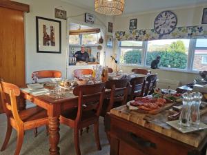 a dining room with a table and chairs and a clock at Geyser Lookout BnB in Rotorua