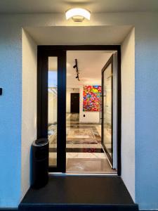 a door to a hallway with a painting on the wall at Eclectic 6 in Satu Mare