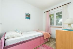 a bedroom with a pink cabinet and a window at Apartments by the sea Maslinica, Solta - 14748 in Maslinica