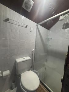 a bathroom with a toilet and a glass shower at Chalé Suiço Bananeiras in Bananeiras