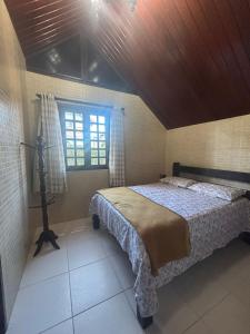 a bedroom with a bed and a window at Chalé Suiço Bananeiras in Bananeiras