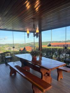 a dining room with a table and a large window at Chalé Suiço Bananeiras in Bananeiras
