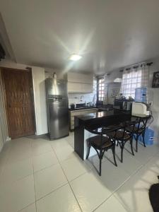 a kitchen with a refrigerator and a table and chairs at Chalé Suiço Bananeiras in Bananeiras +11 photos