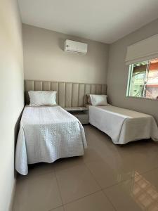 a bedroom with two beds and a window at Sweet Home Away from yours in Lagoa Santa +16 photos