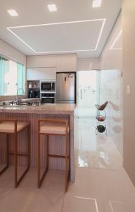 a kitchen with a island with two bar stools at Sweet Home Away from yours in Lagoa Santa