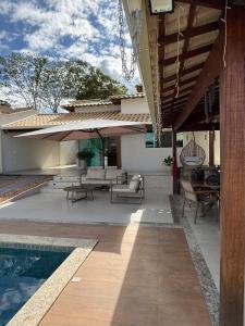 a patio with a table and chairs and a pool at Sweet Home Away from yours in Lagoa Santa