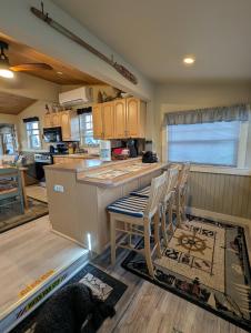 a kitchen with a counter and some chairs in it at Beach Cottage in Saco