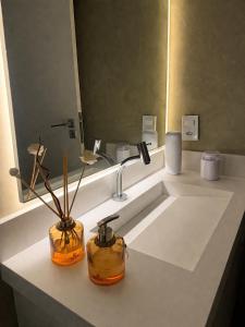 a bathroom with a sink with two vases on it at Lua prime residence in Petrolina +18 photos