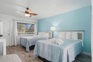 a bedroom with two beds and a ceiling fan at Malibu Resort Motel in St. Pete Beach