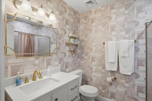 a bathroom with a sink and a toilet and a mirror at Malibu Resort Motel in St. Pete Beach
