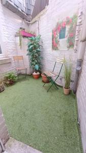 a patio with two chairs and potted plants at Liège City break in Liège