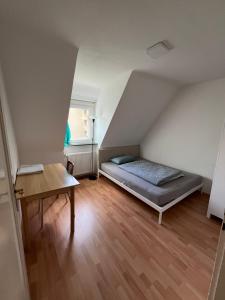 a small bedroom with a bed and a table at Guestroom Hannover Messe in Hannover