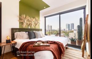 a bedroom with a bed and a large window at Casa Taman by Kukun in Mexico City