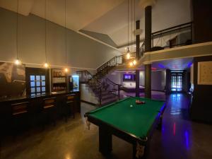 a pool table in a room with a staircase at Blue Suítes - motel in Cascavel