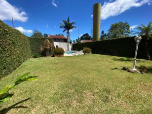 a yard with a lawn with a pole in the grass at Blue Suítes - motel in Cascavel
