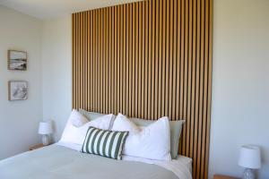 a bedroom with a bed with a striped wall at Tūhua View Retreat in Waihi Beach